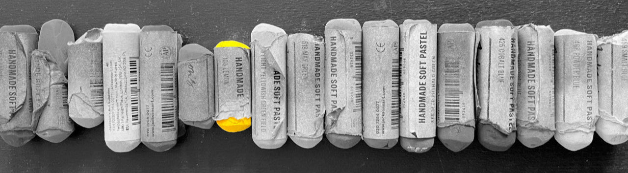 Black and white images of soft pastels, with the yellow pastel in colour