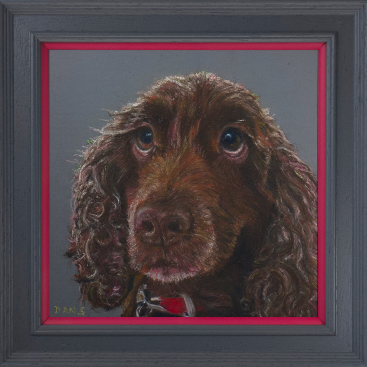 Picture of a brown cocker spaniel's face with a grey background in a grey frame with pink border