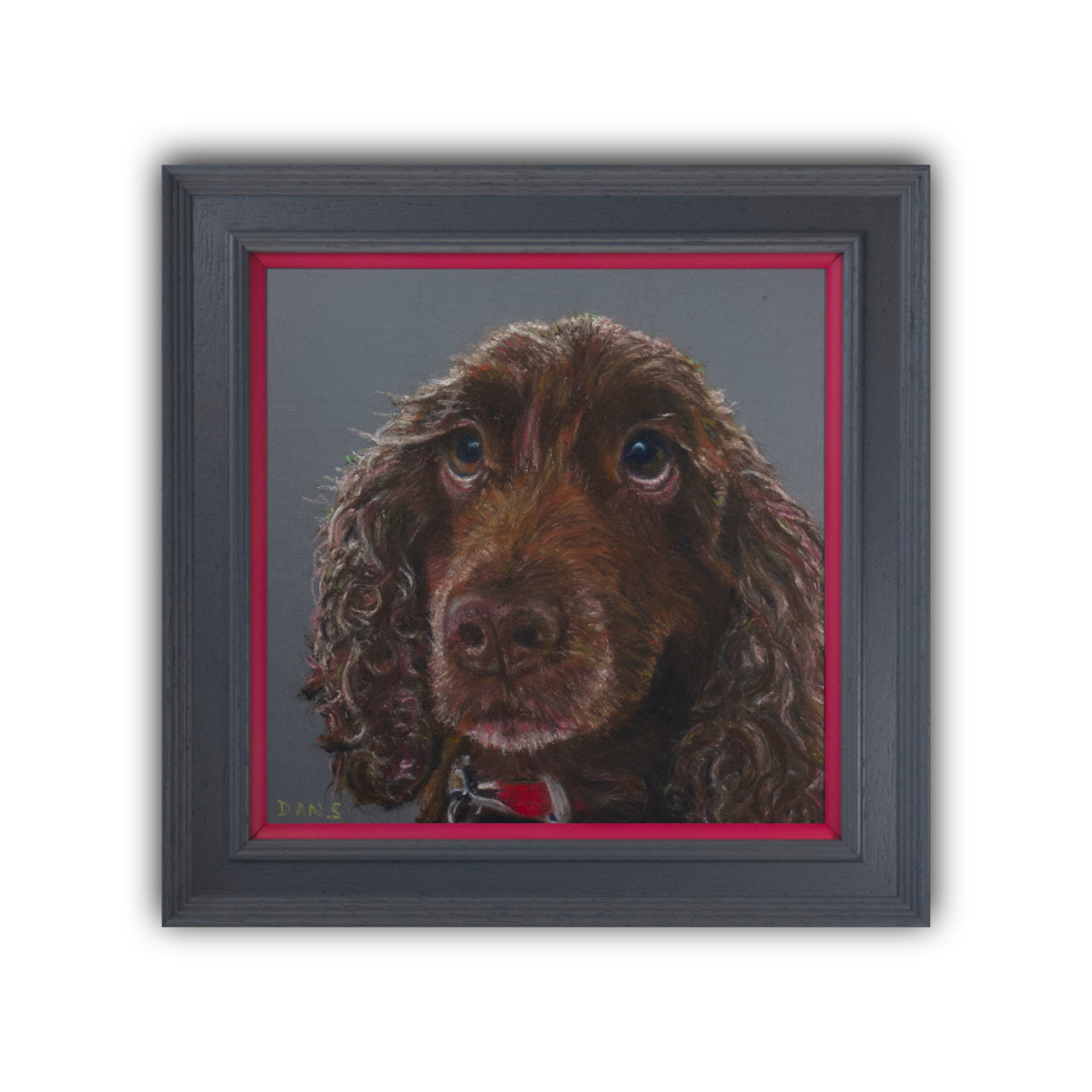 Picture of a brown cocker spaniel's face with a grey background in a grey frame with pink border