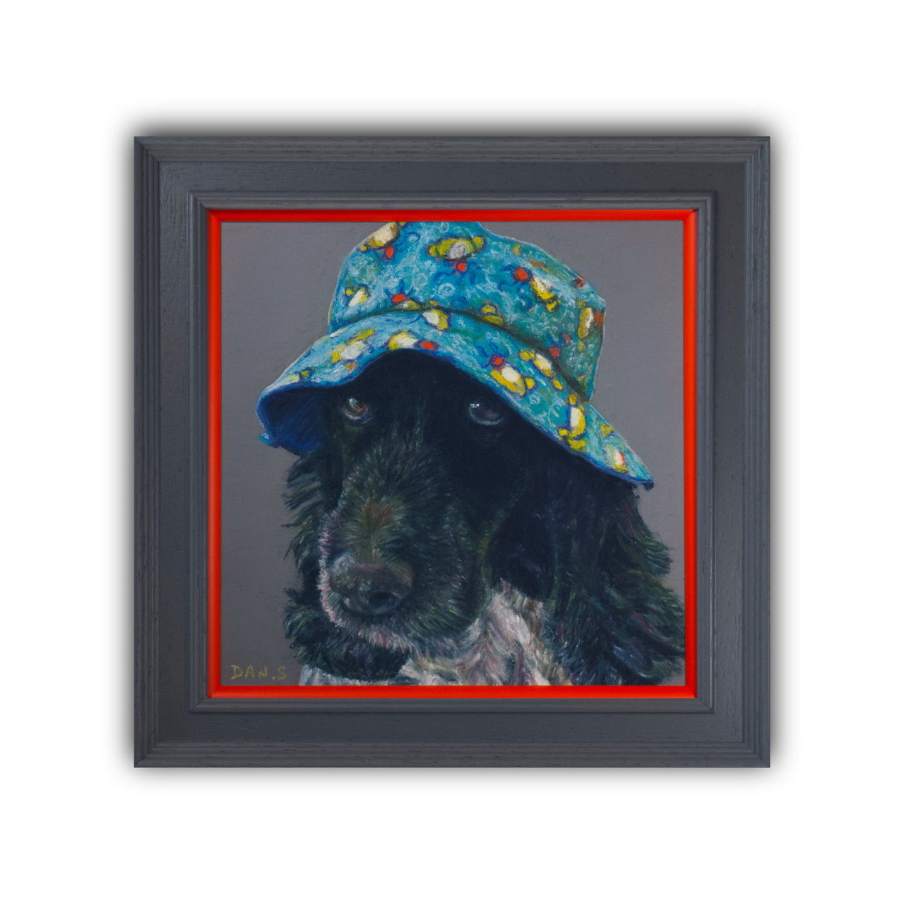 Picture of a cocker spaniel wearing a colourful bucket hat on a grey background in a grey frame with orange border