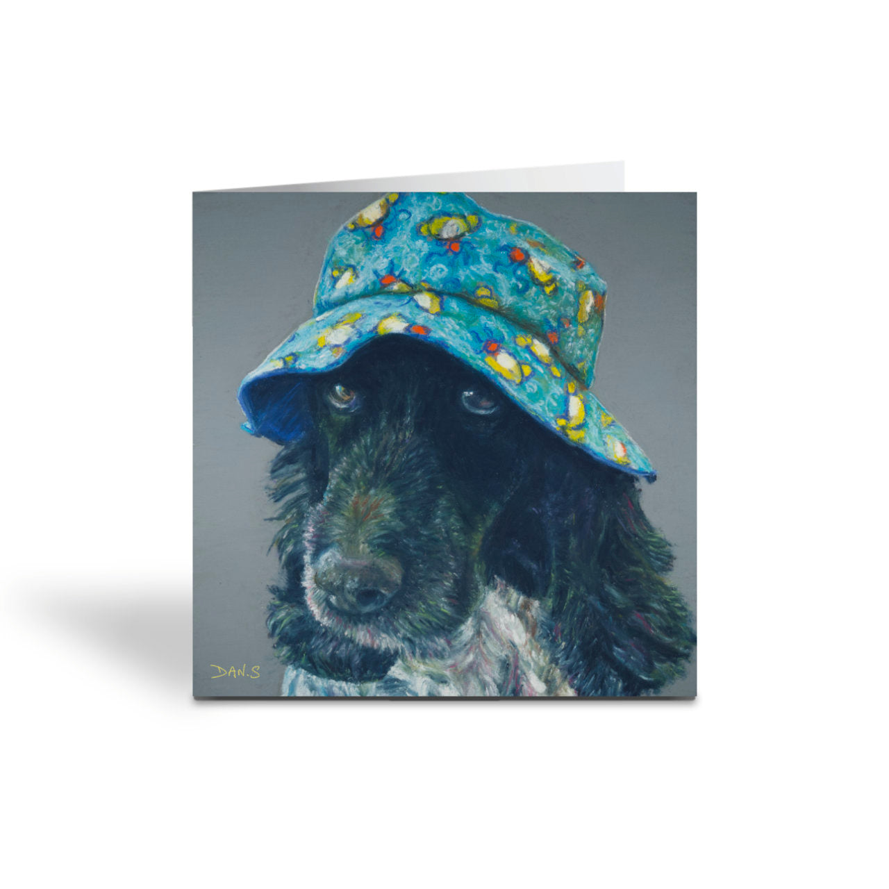 Card featuring a cocker spaniel wearing a colourful bucket hat on a grey background 