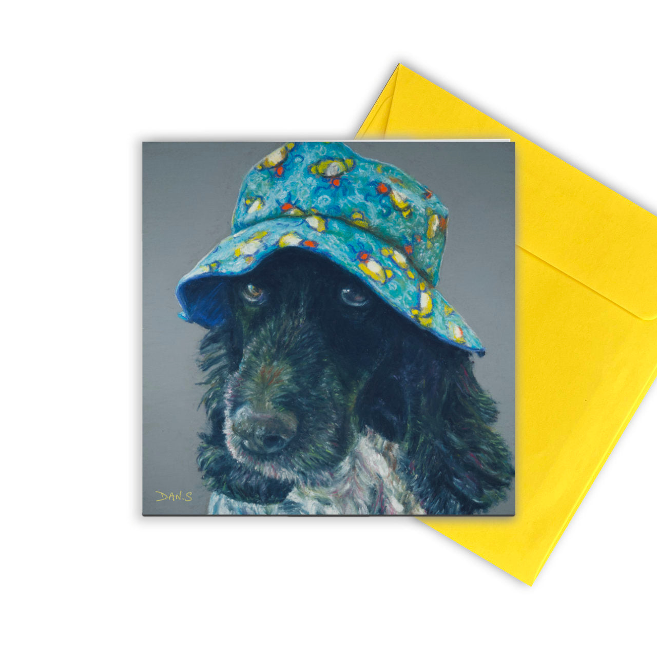 Card featuring a cocker spaniel wearing a colourful bucket hat with yellow envelope